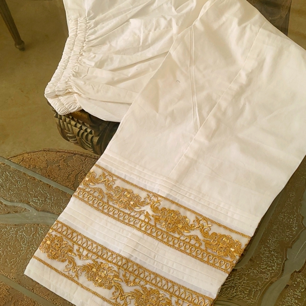 Cotton pants with gold embroidery.